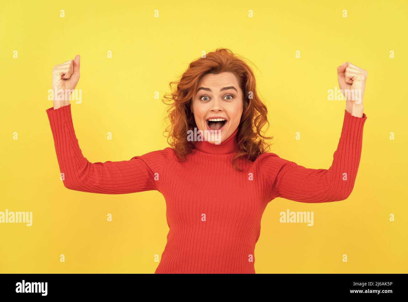 redhead dame célébrant le succès. enfin, la femme heureuse exprime la positivité. Banque D'Images