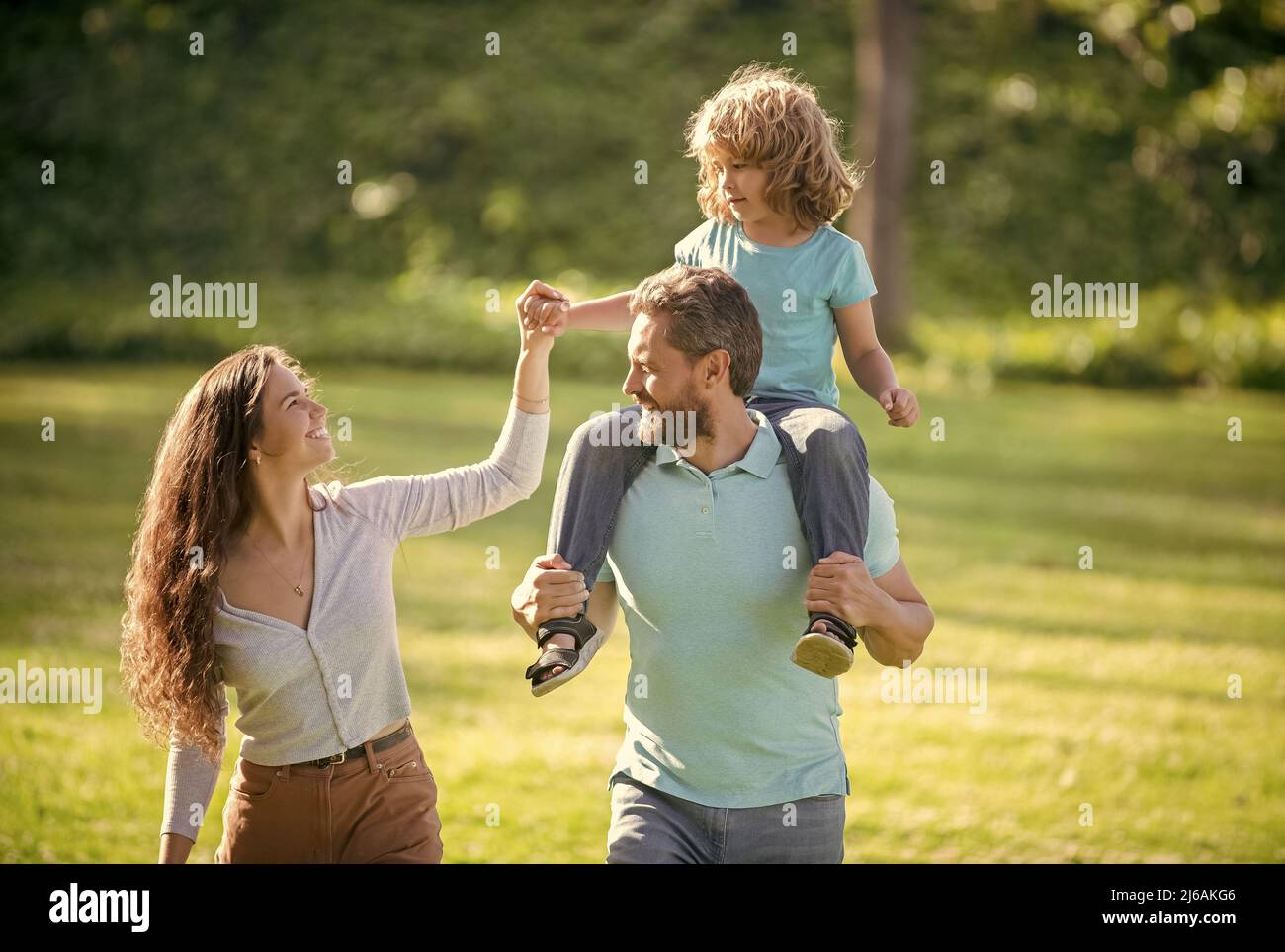 Favoriser les soins. Parents d'accueil et fils. La mère et l'enfant qui s'enravent sur le père. Famille adoptive Banque D'Images