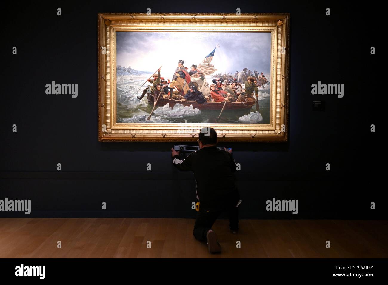 L’installateur Wwill Fuentes vérifie le niveau de la peinture « Washington Crossing the Delaware » de l’artiste Emanuel Leutze exposée lors de Christie’s 20th and 21st Century Art Press Preview, New York, NY, le 29 avril 2022. (Photo par Anthony Behar/Sipa USA) Banque D'Images