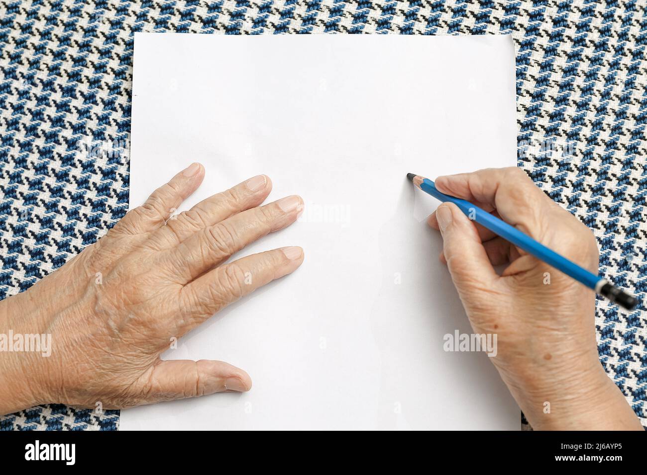 femme âgée écrivant sur du papier vierge Banque D'Images