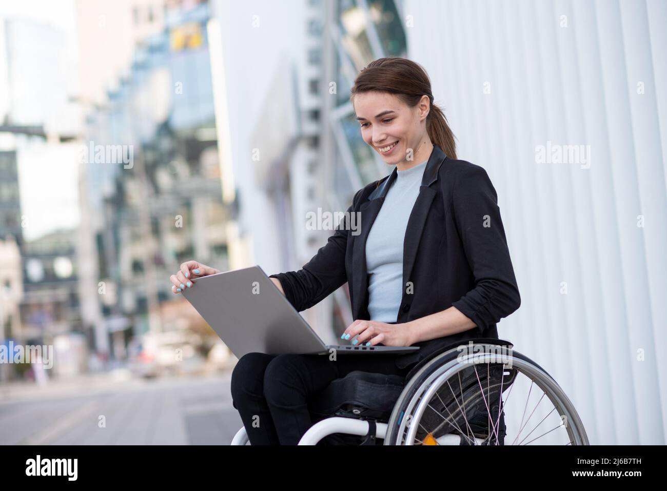 Femme d'affaires handicapée qui utilise un fauteuil roulant travaillant à l'extérieur Banque D'Images