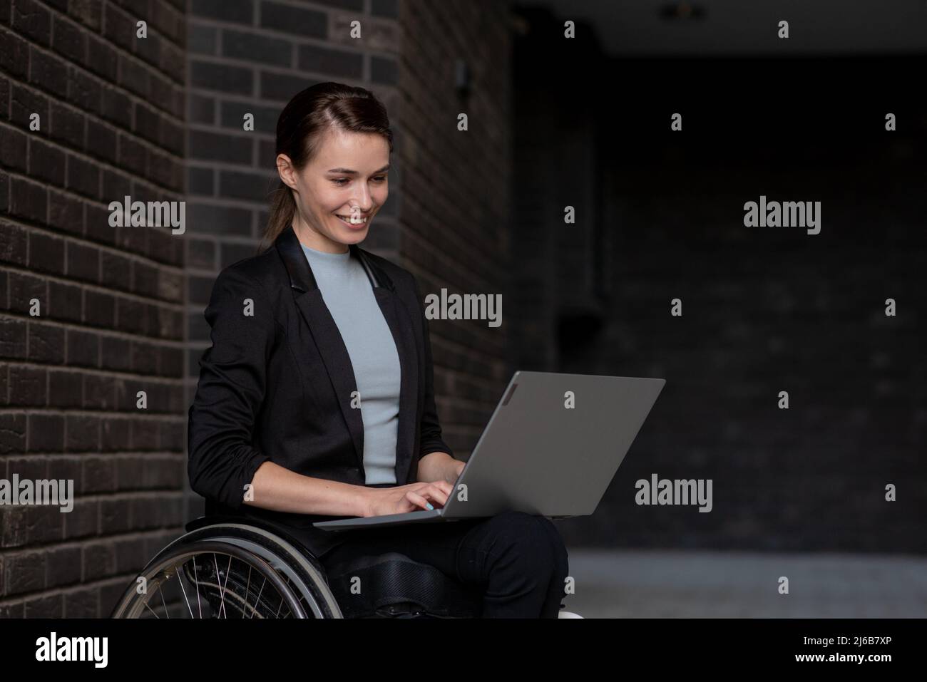 Femme d'affaires handicapée qui utilise un fauteuil roulant travaillant à l'extérieur Banque D'Images