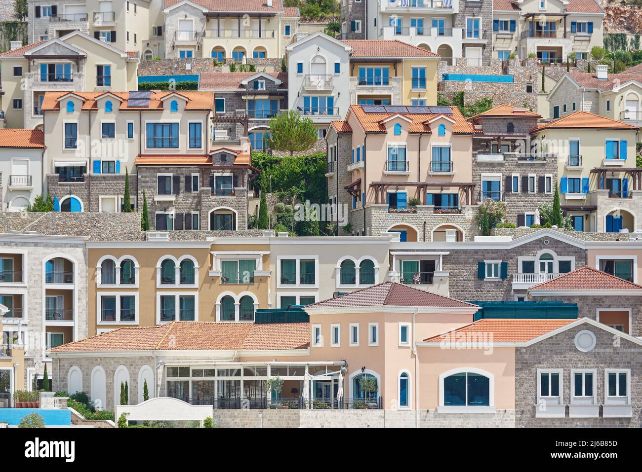 Paysage de la ville avec des maisons sur un flanc de montagne dans la baie de Lustica, Monténégro Banque D'Images