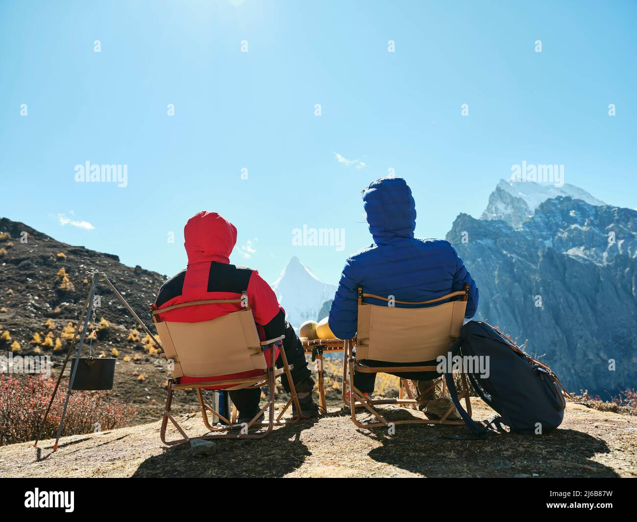 vue arrière d'un couple asiatique assis dans des chaises au sommet de la montagne, vue sur le parc national de yading, comté de daocheng, province du sichuan, chine Banque D'Images