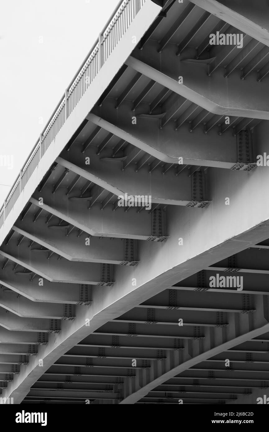 Construction de travée de pont en acier, vue de dessous avec poutres grises, photo verticale noir et blanc Banque D'Images