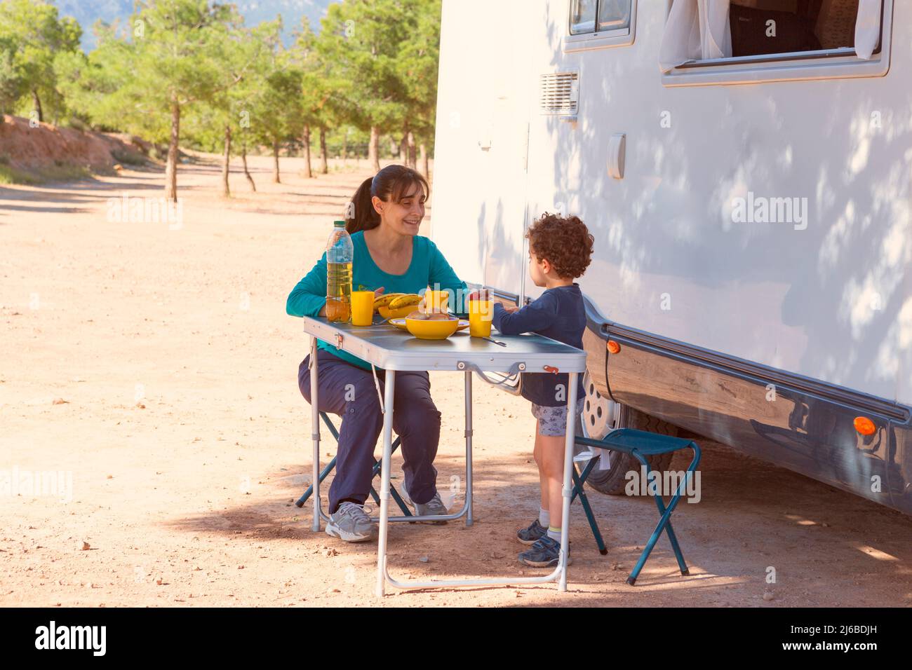 enfant et mère pique-nique à côté de la maison de moteur Banque D'Images