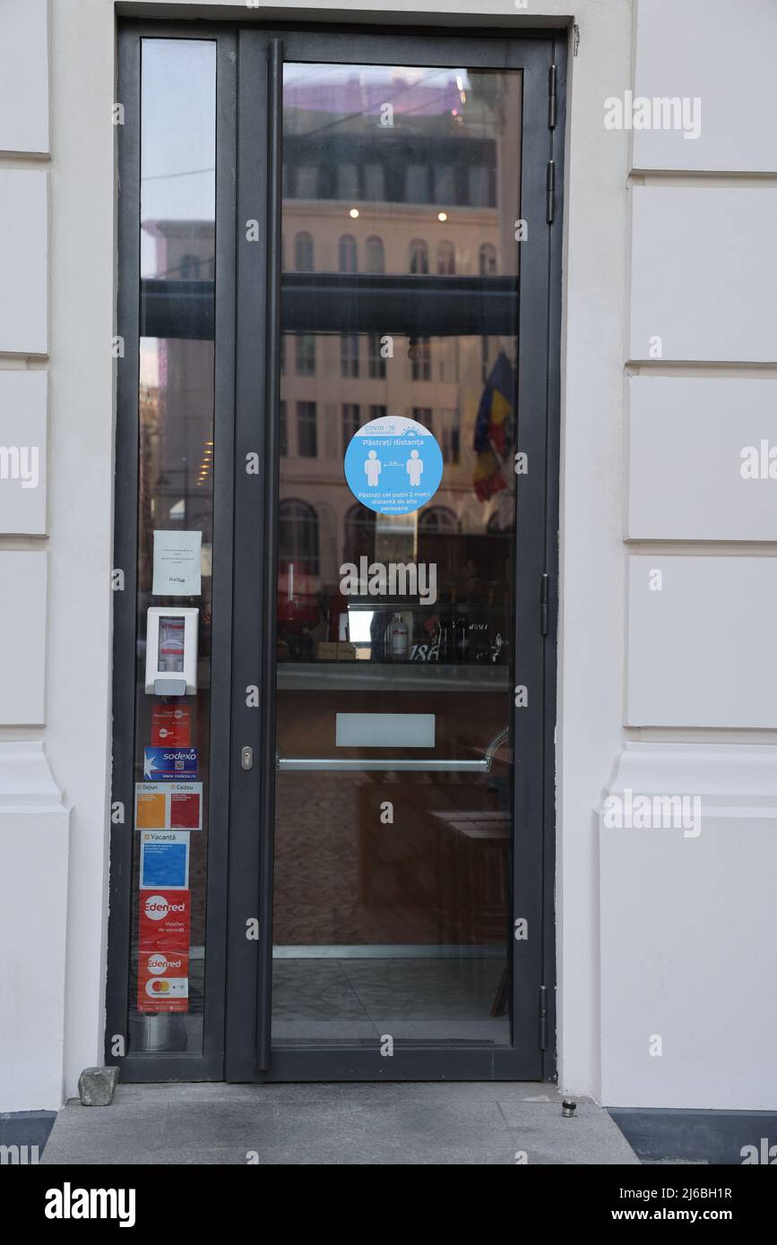 Panneau sur la porte d'entrée d'un restaurant de l'hôtel rappelant de garder une distance de 1,5 mètres (distance sociale) à Bucarest, Roumanie Banque D'Images