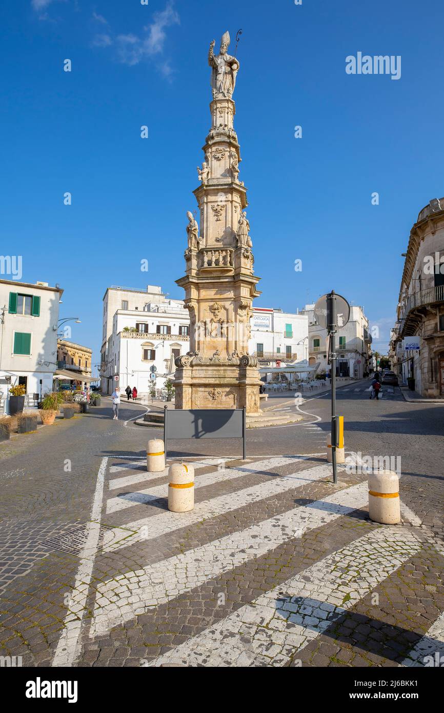 Colonna di Sant'Oronzo par la via Matteo Renato Imbriani à Ostuni. Province de Brindisi, Pouilles (Puglia) Italie. Colonne en pierre très décorée honorant t Banque D'Images