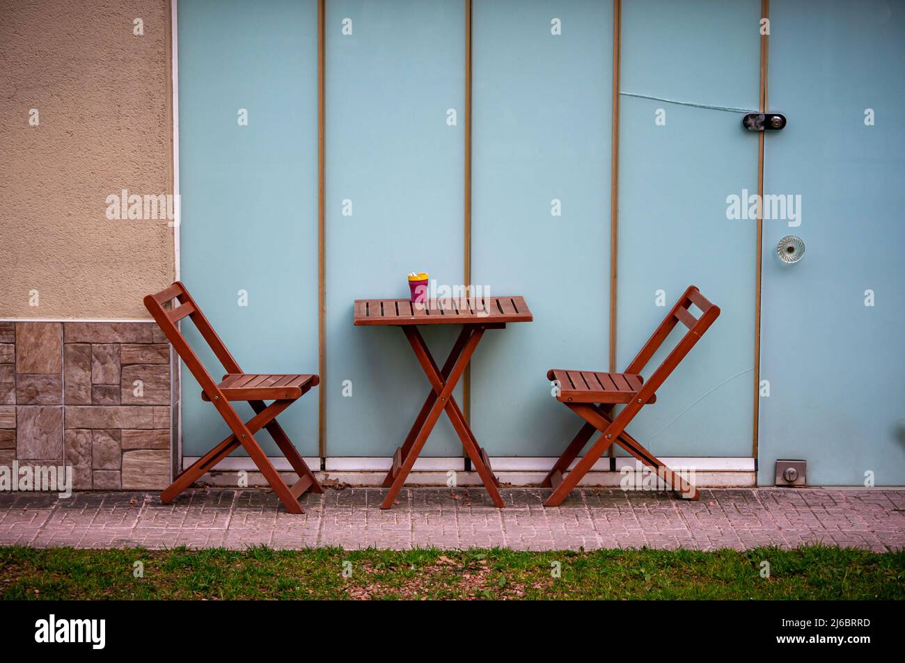 Table et chaises en bois devant un mur en verre. Banque D'Images