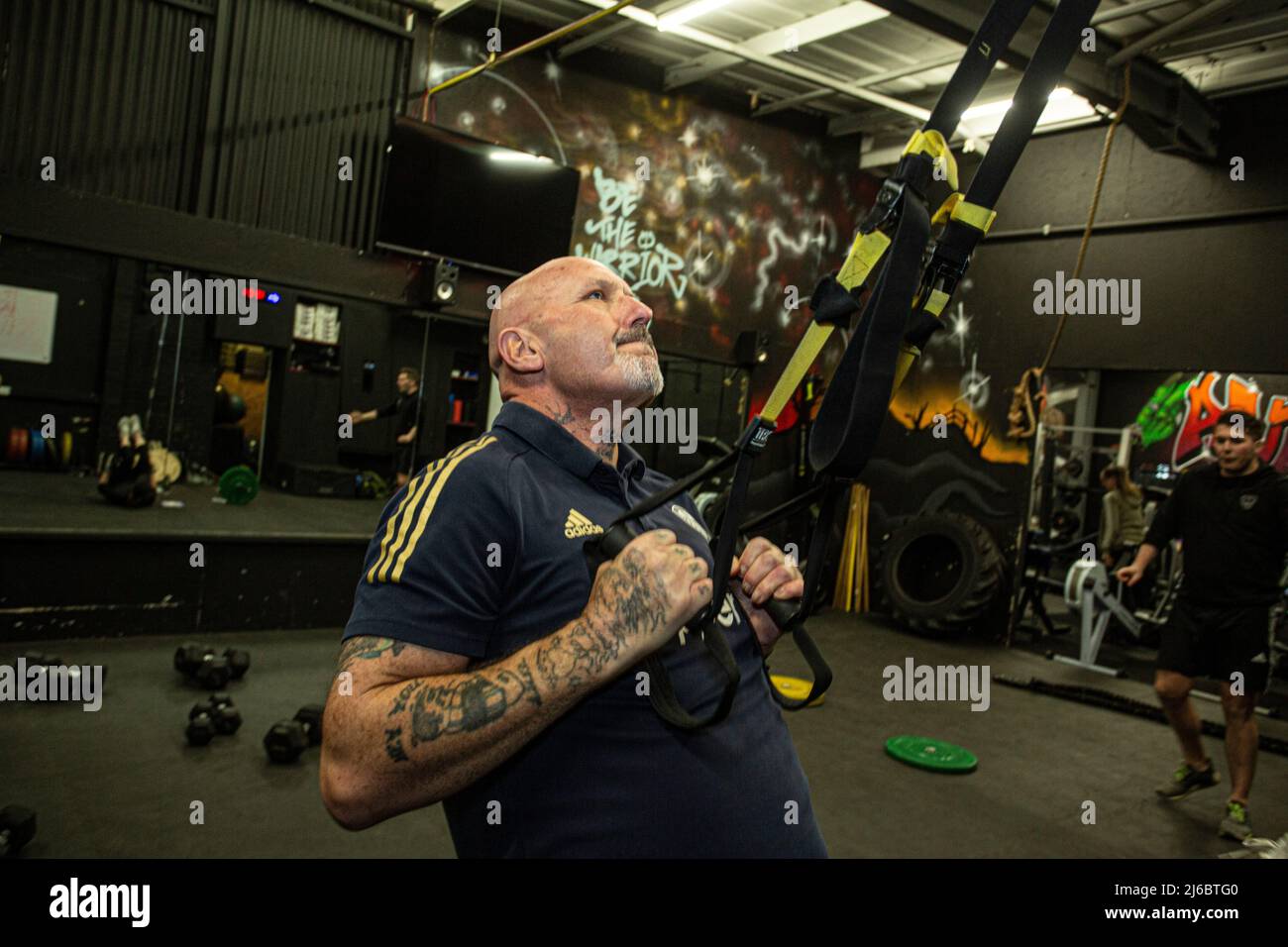 Homme s'exerçant avec des cordes élastiques dans la salle de gym , West Yorkshire, Angleterre. Banque D'Images