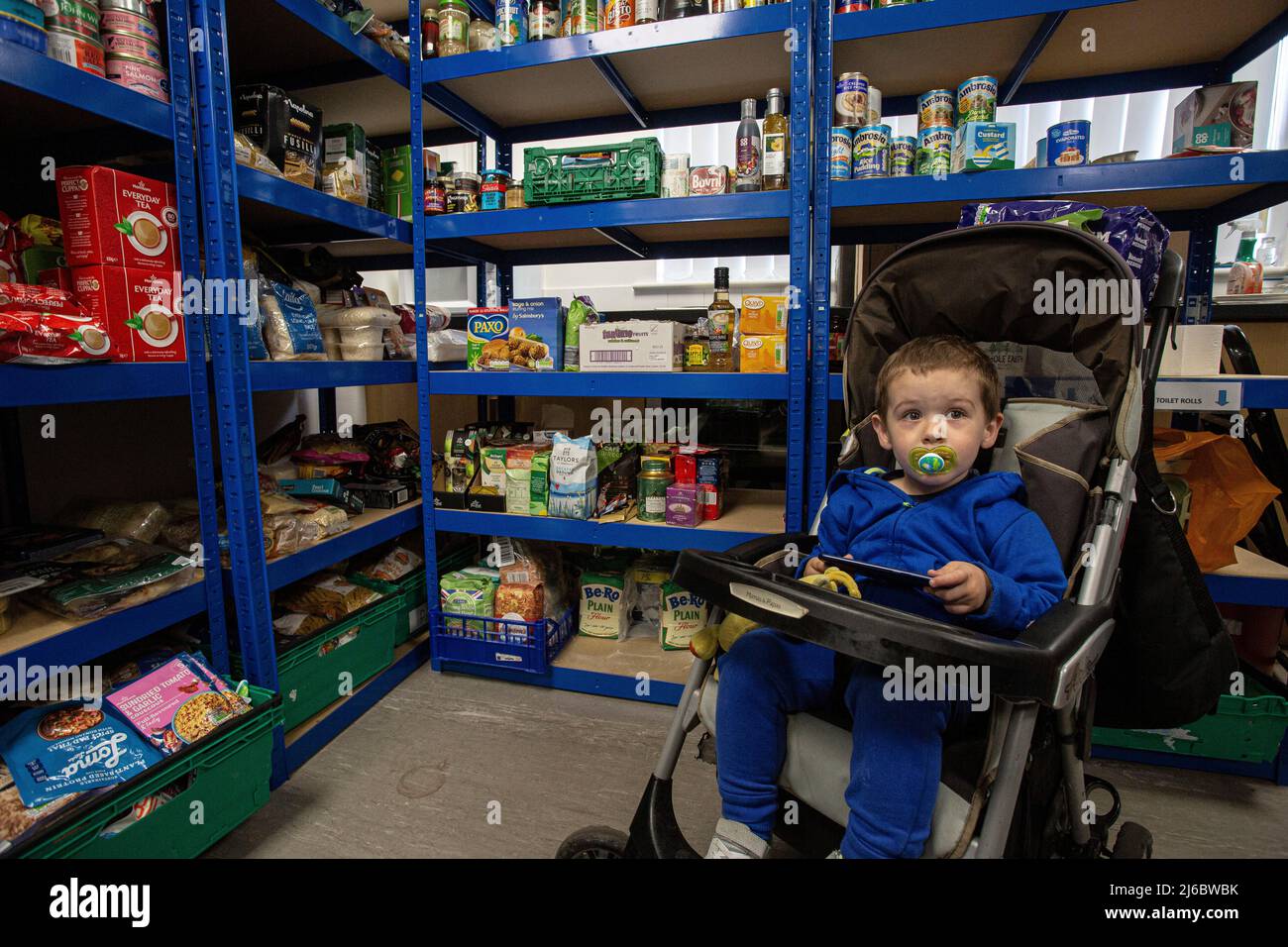 Jeune enfant dans une poussette dans une banque alimentaire en Angleterre . Banque D'Images