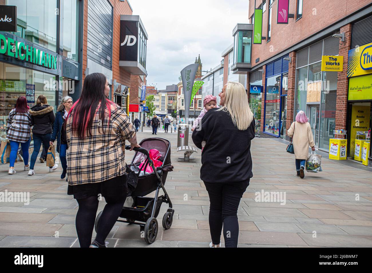 Mère avec des promenades de bébé dans le centre commercial Trinity Walk à Wakefield, West Yorkshire, Angleterre. Banque D'Images