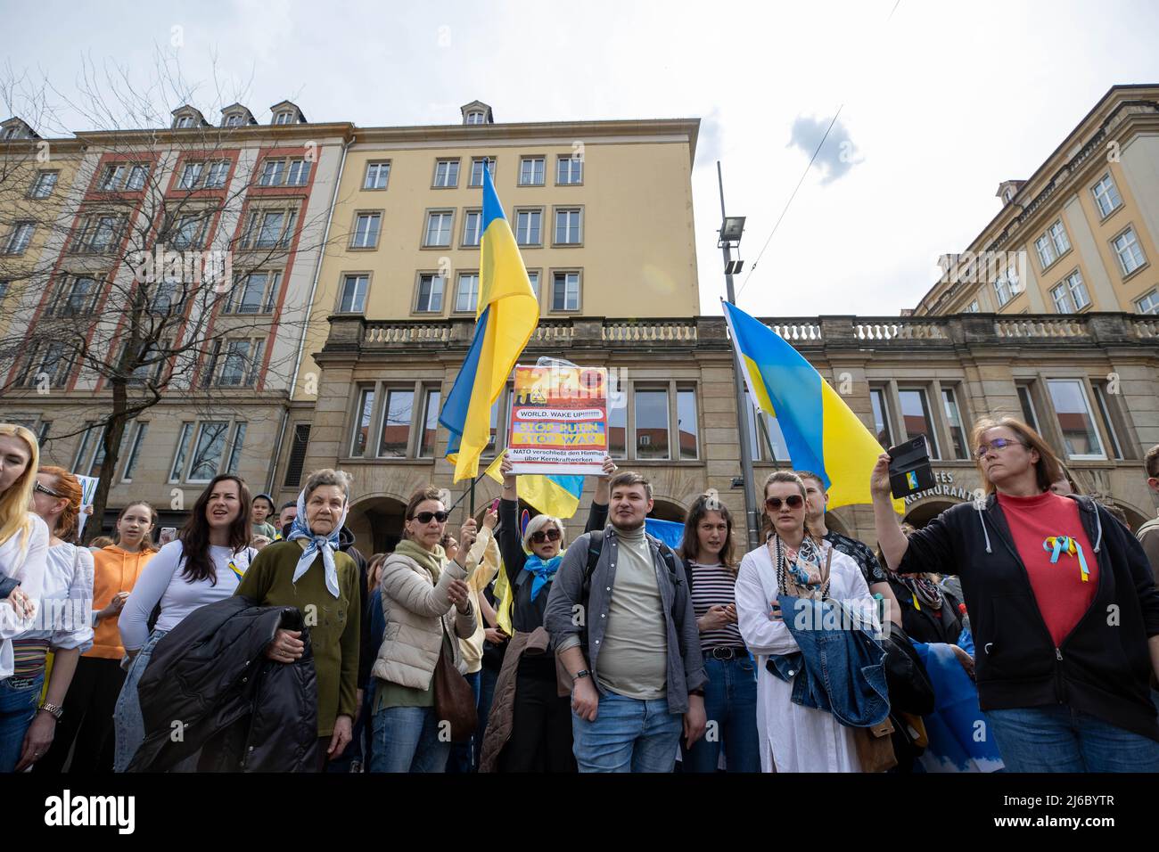 30 avril 2022, Saxe, Dresde: Une femme tient un signe qui lit LE MONDE. RÉVEILLEZ-VOUS !!!!!! dans l'air. Le contre-événement contre le rassemblement pro-russe avec le titre: 'Solidarité avec le peuple de l'Ukraine! Tout ensemble contre la guerre d'agression de Poutine!'mène aussi le long de la rue Wilsdruffer à Dresde. Photo: Daniel Schäfer/dpa Banque D'Images