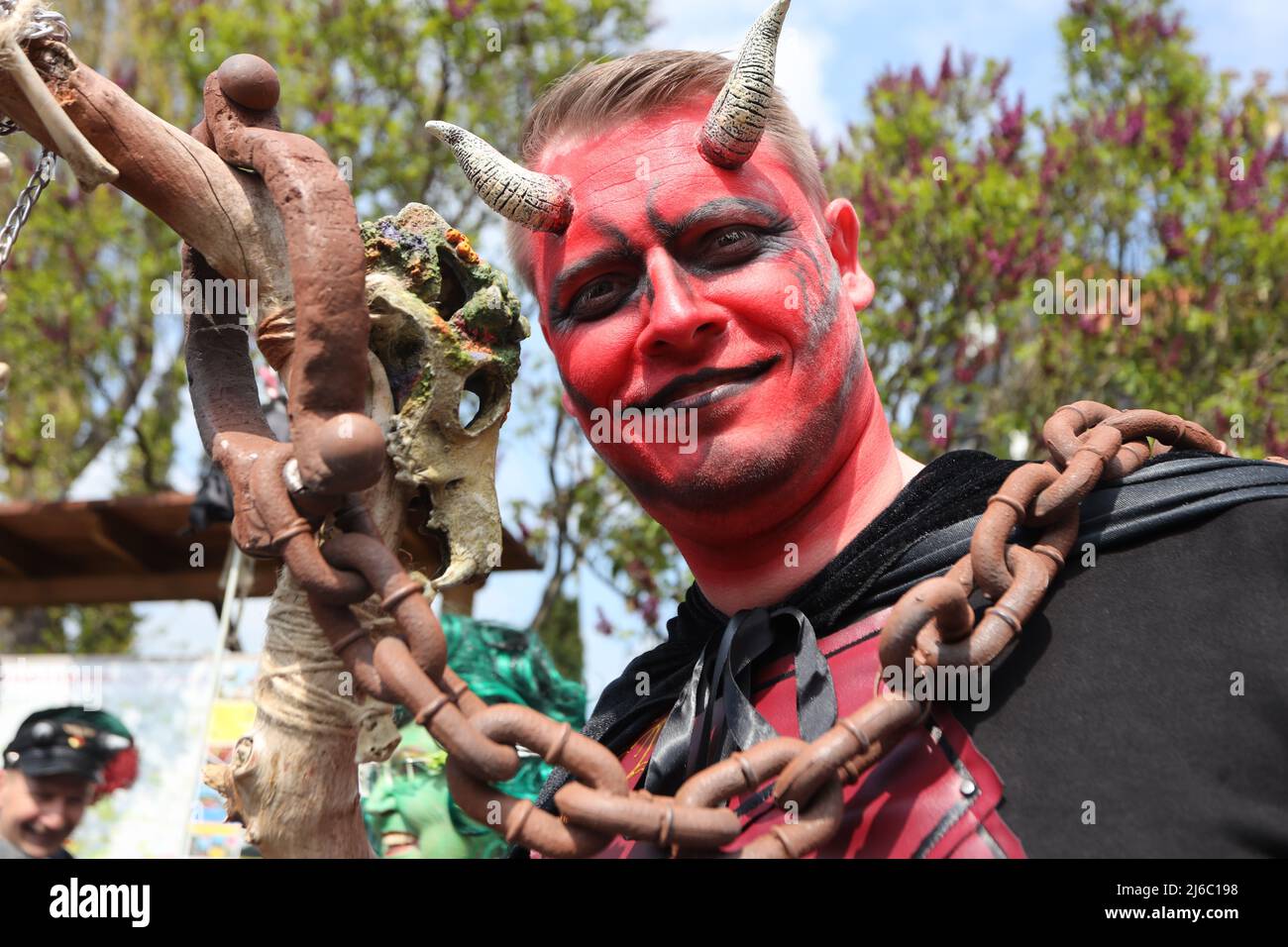 30 avril 2022, Saxe-Anhalt, Wernigerode: Un homme dans un costume de diable se dresse sur la place du marché. Le jour de Walpurgis, les personnes en costumes de sorcières et de diables se sont traditionnellement réunies pour s'éprendre à l'hôtel de ville de Wernigerode. Dans toute la résine, en outre, dans d'autres régions et er nuit à 1. Que le Walpurgisfest traditionnel soit célébré. Les places fortes incluent Thale et Schierke am Brocken. Photo: Matthias Bein/dpa Banque D'Images