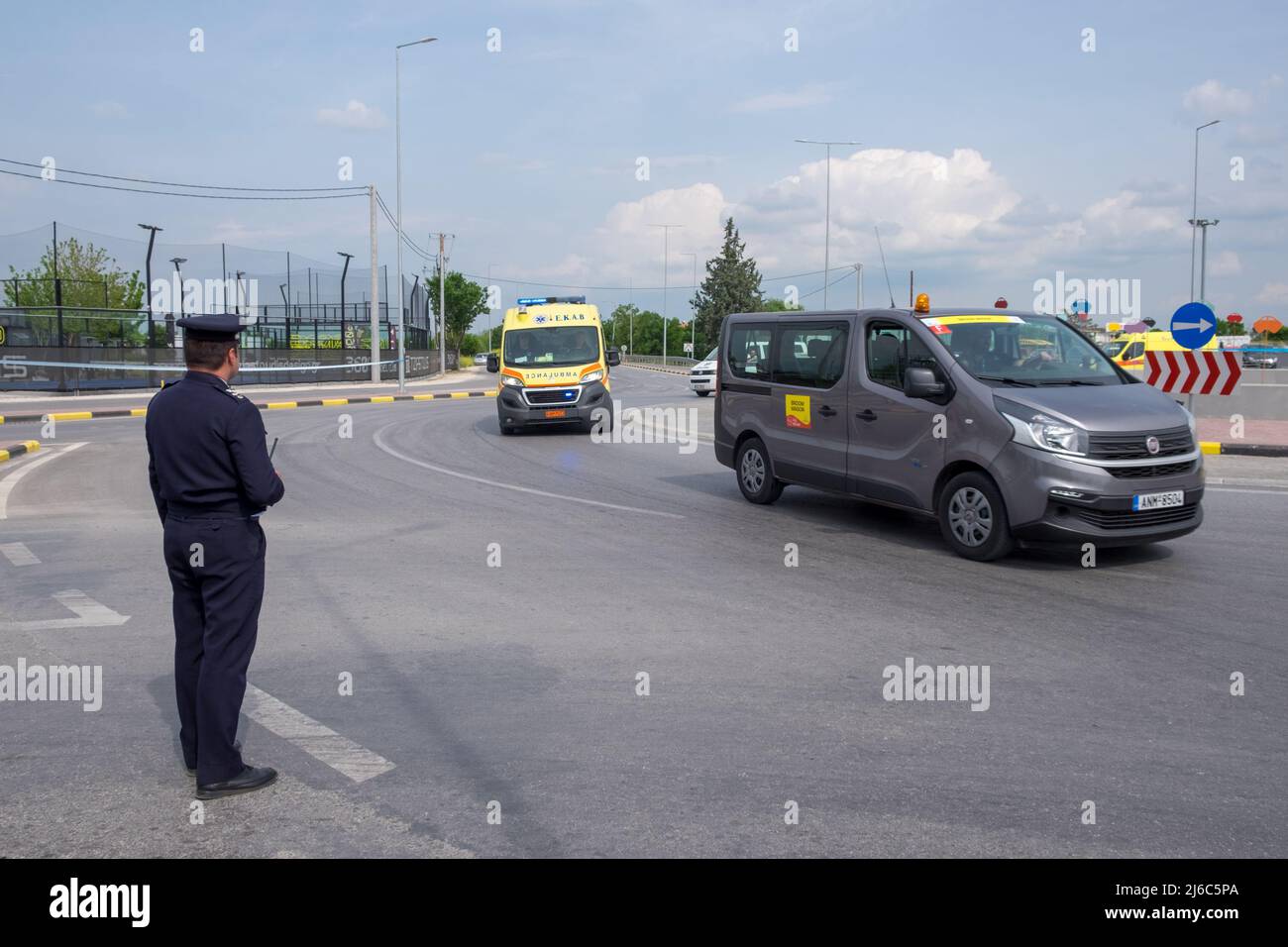 Un policier contrôlant la circulation avec un minibus neutre de soutien après les cyclistes dans la course cycliste International Tour of Hellas 2022 Banque D'Images