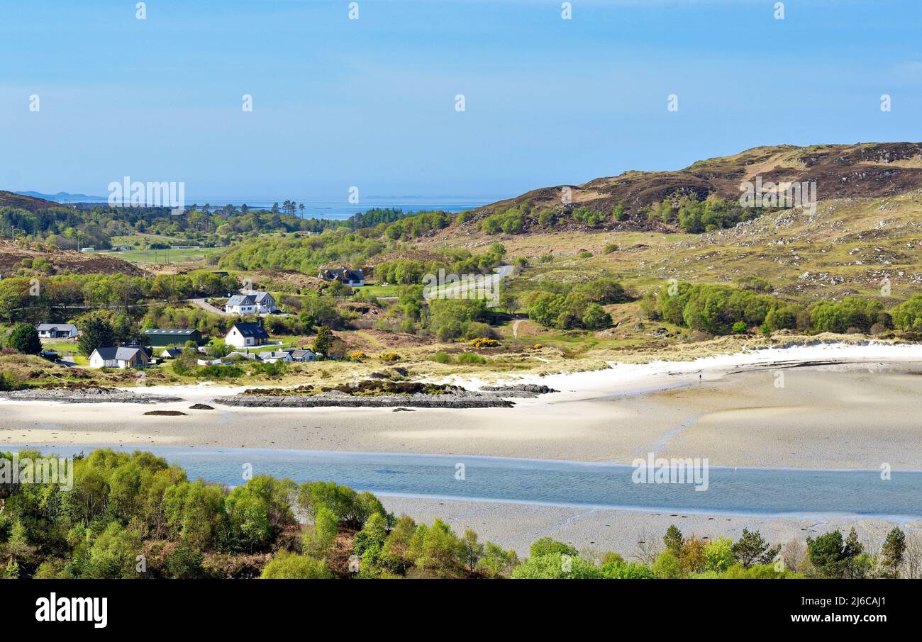 MORAR HIGHLAND SCOTLAND ARBRES AU DÉBUT DU PRINTEMPS UNE PLAGE DE SABLE ET DES MAISONS VOISINES SUR LA RIVE Banque D'Images