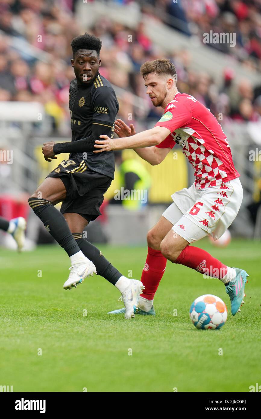 30 avril 2022, Rhénanie-Palatinat, Mayence: Football: Bundesliga, FSV Mainz 05 - Bayern Munich, Matchday 32, Mewa Arena. Alphonso Davies (l) de Munich et Anton Stach de Mayence se battent pour le ballon. Photo: Thomas Frey/dpa - NOTE IMPORTANTE: Conformément aux exigences du DFL Deutsche Fußball Liga et du DFB Deutscher Fußball-Bund, il est interdit d'utiliser ou d'avoir utilisé des photos prises dans le stade et/ou du match sous forme de séquences d'images et/ou de séries de photos de type vidéo. Banque D'Images