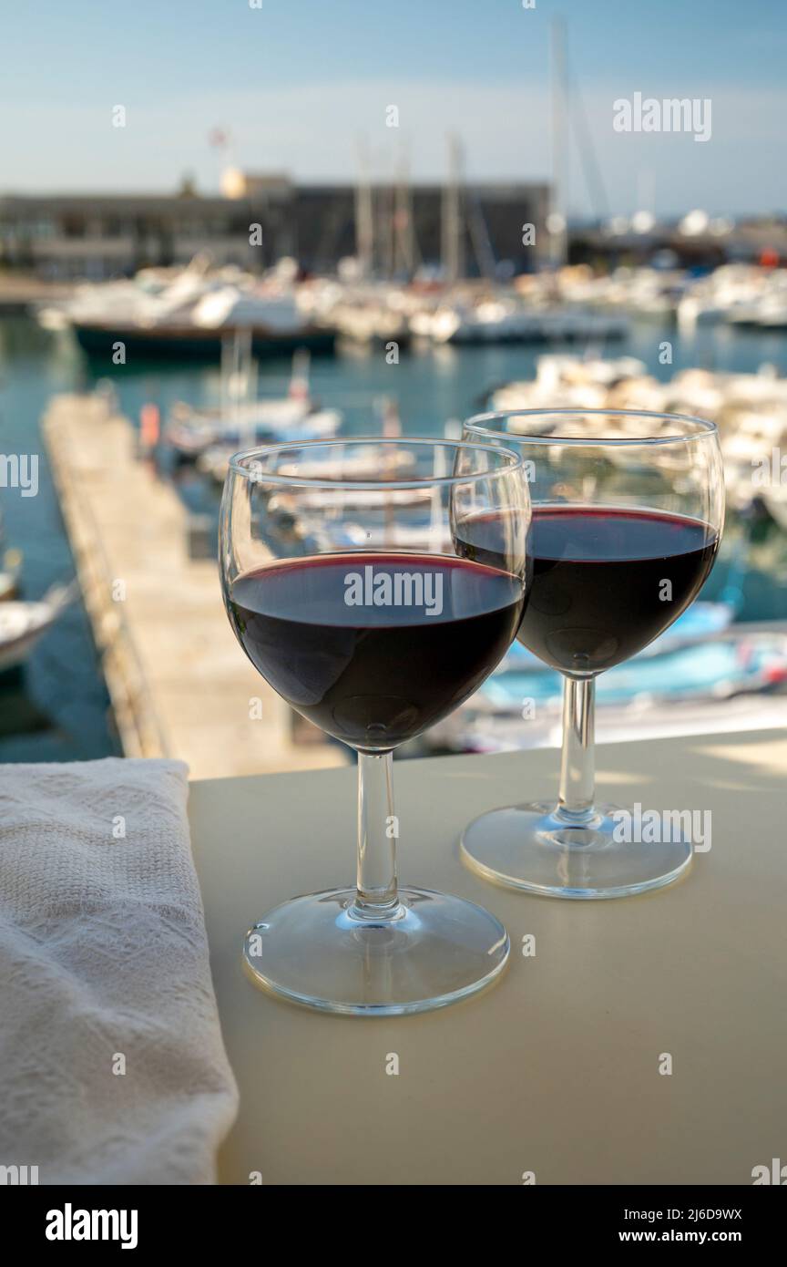 Boire du vin rouge sec sur la terrasse extérieure avec vue sur le vieux  port de pêcheur avec des bateaux colorés à Cassis, Provence, France Photo  Stock - Alamy