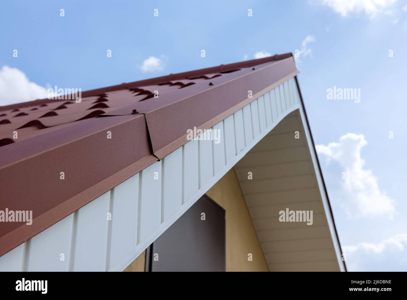 Toit moderne recouvert d'un toit en métal rouge revêtu d'un effet de carrelage Banque D'Images