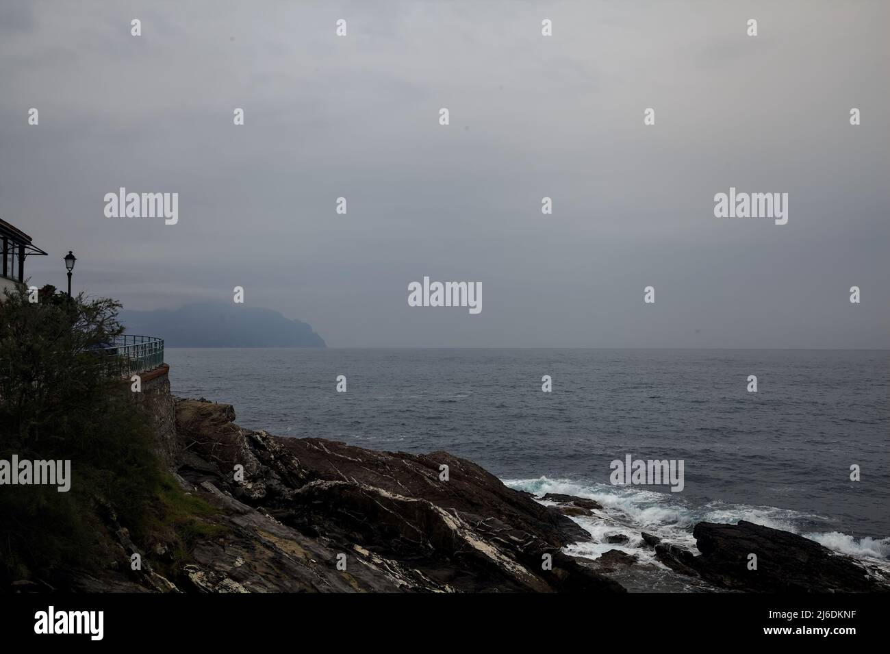 Falaise au bord de la mer par jour pluvieux et nuageux Banque D'Images