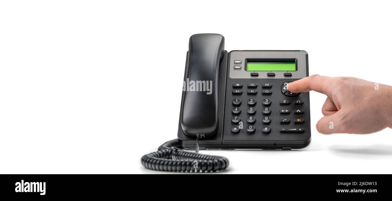 Téléphone noir avec VOIP isolé sur fond blanc. Support client, concept de centre d'appels. Main tenant le récepteur de téléphone voip sur fond blanc b Banque D'Images