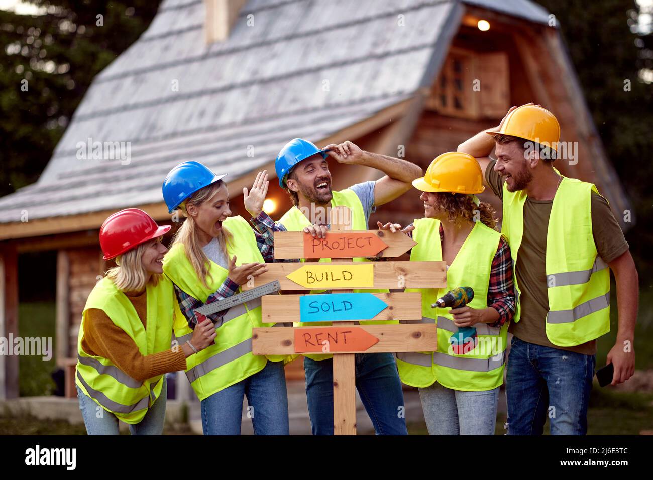 Une équipe de jeunes travailleurs de la construction travaille ensemble sur un projet de chalet de montagne Banque D'Images