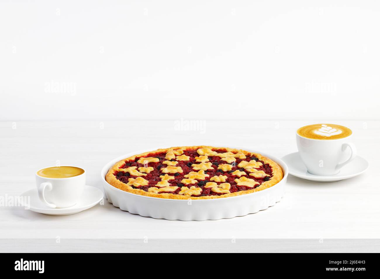 Crostata maison avec tarte aux baies et deux tasses de café - cappuccino et expresso sur table en bois blanc. CopySpace. Banque D'Images Crostata maison avec tarte aux baies et deux tasses de café - cappuccino et expresso sur table en bois blanc. CopySpace. Banque D'Images