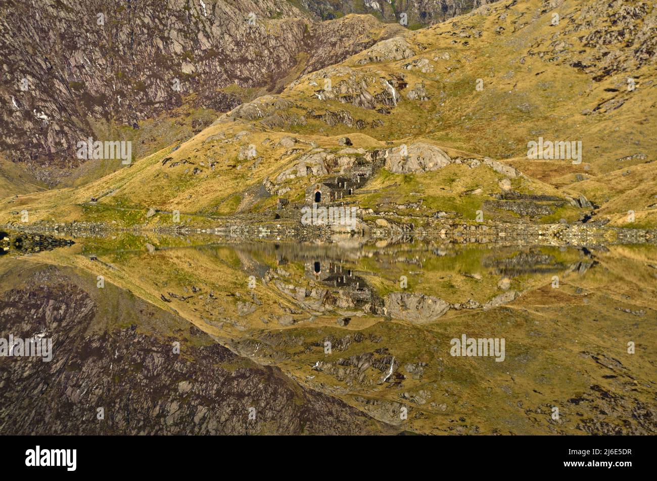 Les ruines de l'ancien moulin à écraser se reflètent à Llyn Llydaw sur la piste de Miner à Mt Snowdon, pays de Galles, Royaume-Uni Banque D'Images