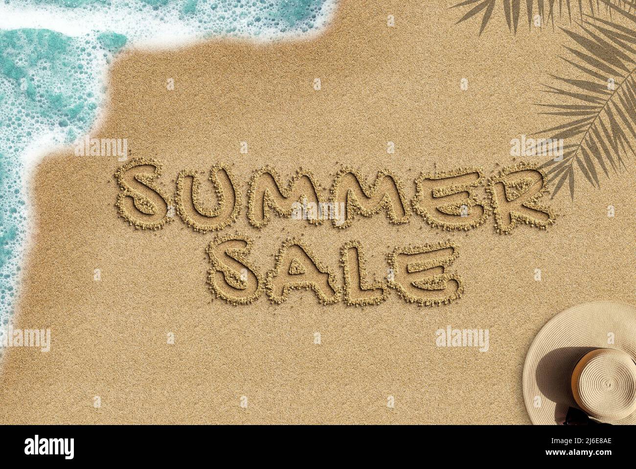 Texte de vente d'été sur une plage de sable, vue de dessus, concept de campagne d'été de commerce électronique, idée de bannière de vente d'été, vague de mer ombre de palmier, composition de chapeau de paille Banque D'Images