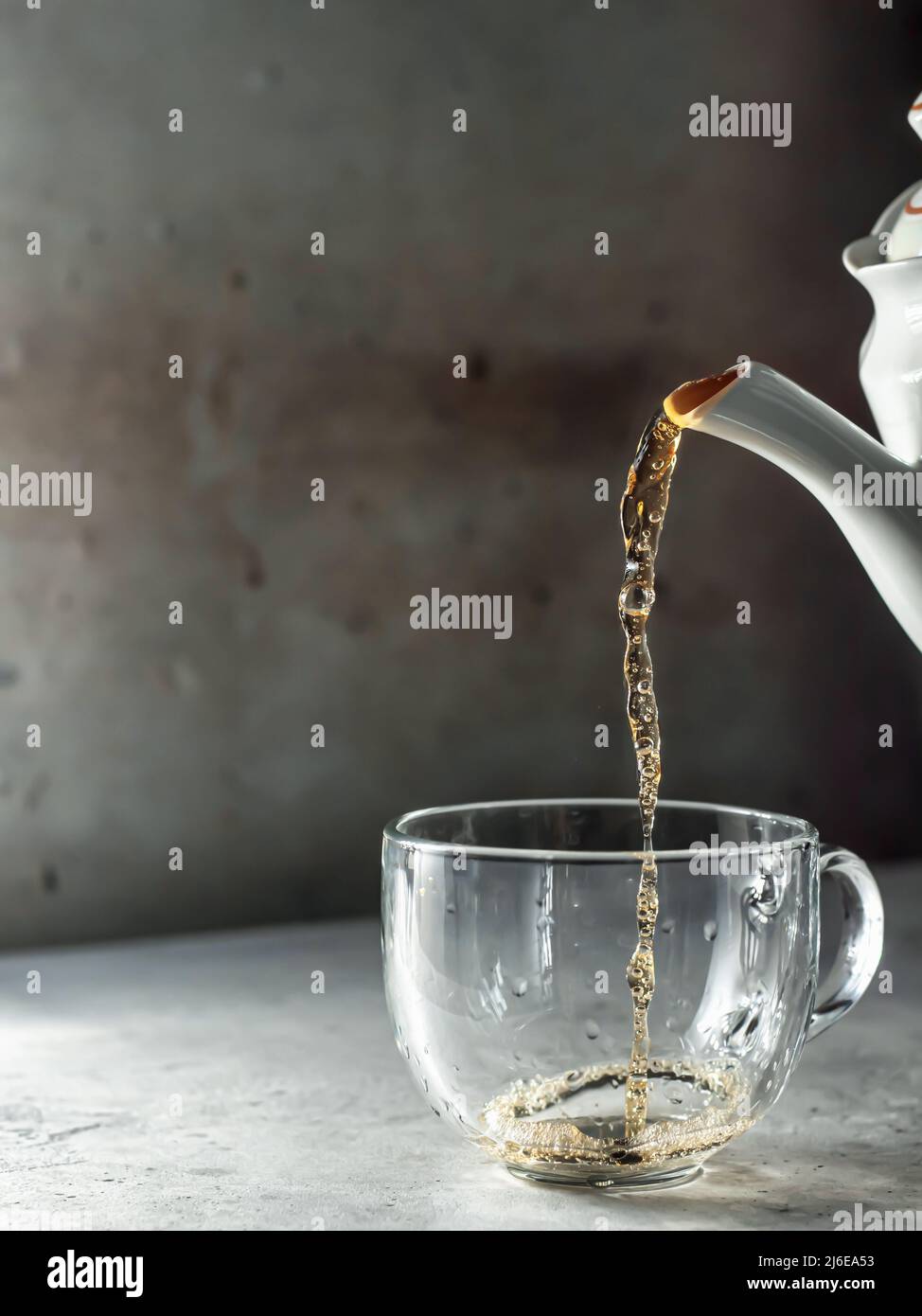 Le thé est versé dans une tasse de thé en verre avec de la vapeur Banque D'Images