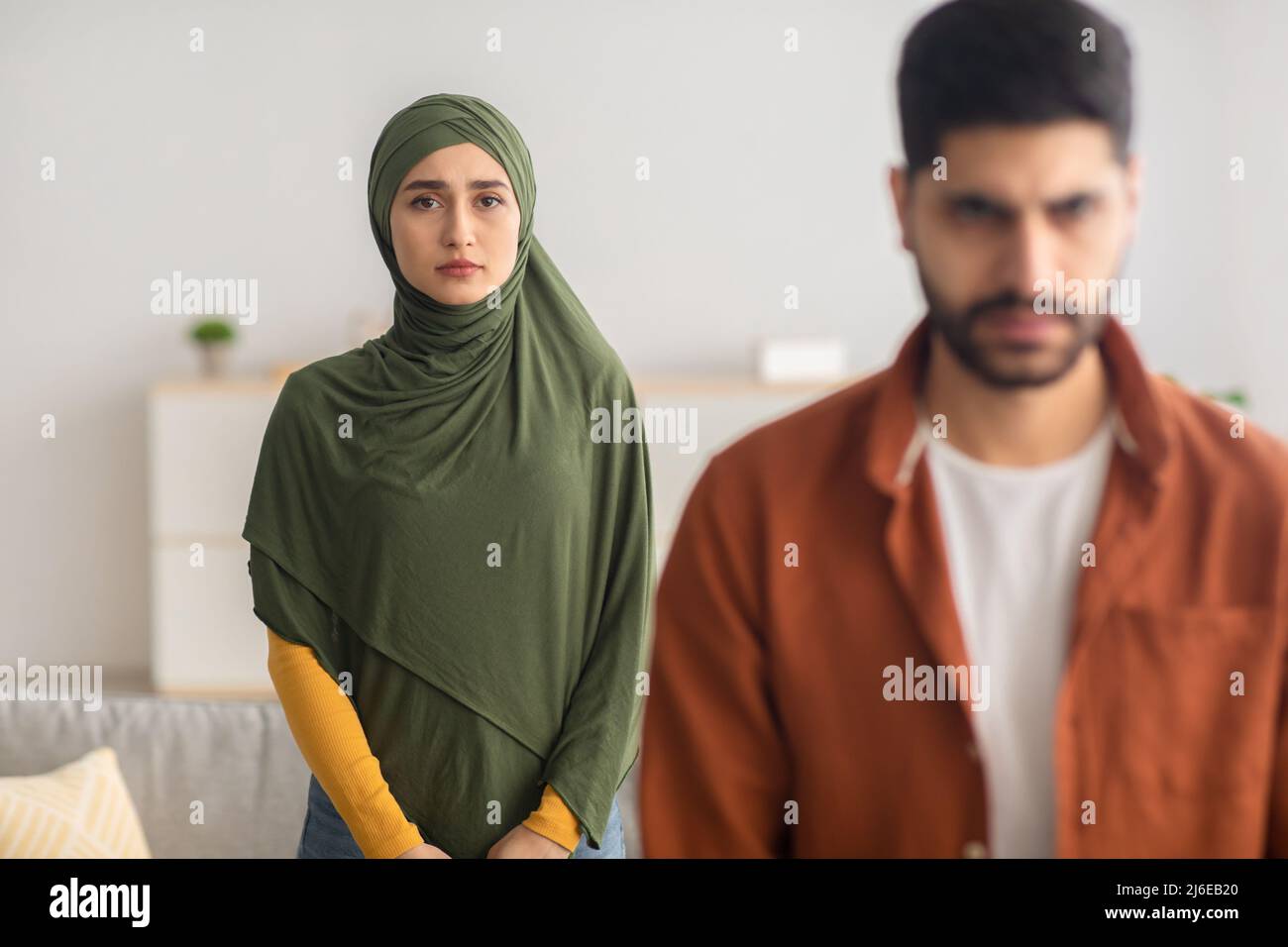 Une femme musulmane malheureuse se tenant derrière le retour de son mari à la maison Banque D'Images