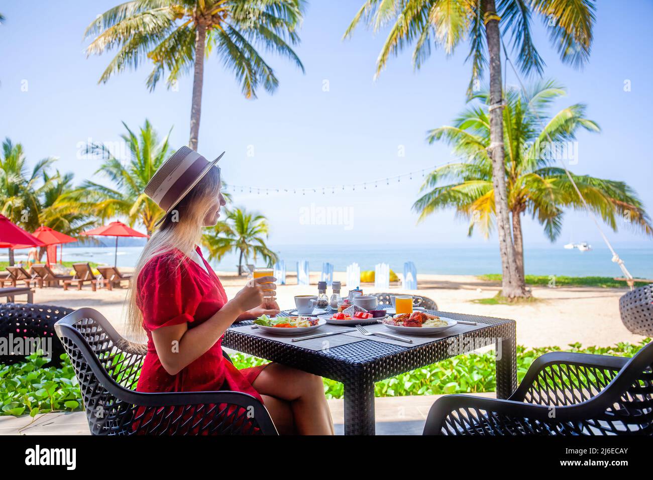 Petit déjeuner tropical sain dans l'hôtel avec plage de sable, palmiers et balançoire Banque D'Images