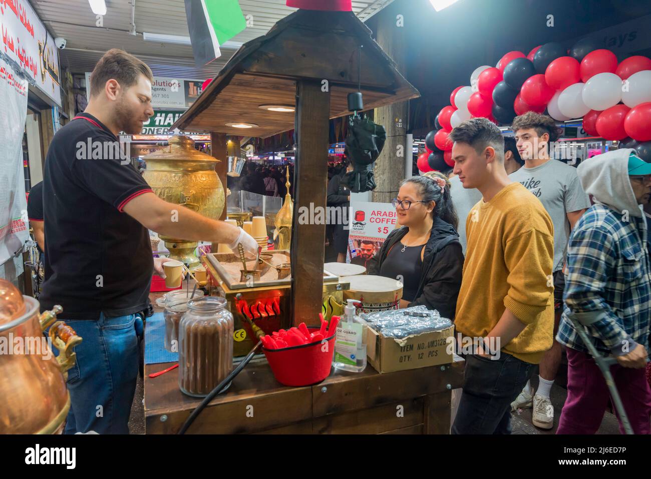 30 avril, Lakemba, Sydney, Australie : la dernière nuit du Ramadan à Sydney, le festival des nuits du Ramadan bat son plein du coucher du soleil de 17,30 h à 02,00 h le lendemain matin. Ici, un homme fait du café de sable chaud pour un client en attente. De longues files d'attente de gens serpentent dans la rue en attendant d'acheter ce et d'autres aliments des nombreuses nations représentées à ce marché chaque soir pendant le festival. Banque D'Images