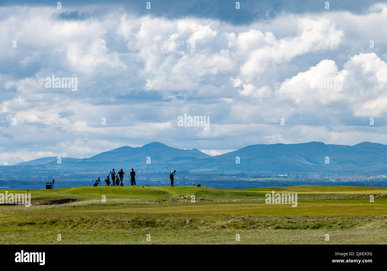 East Lothian, Écosse, Royaume-Uni, mai 1st 2022. Météo au Royaume-Uni : soleil sur la côte est du Lothian. Golfeurs jouant au golf sur la côte de Firth of Forth avec une vue sur les collines de Pentland au loin Banque D'Images