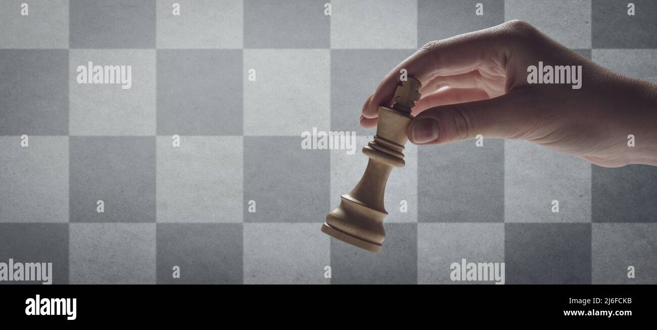 Joueur d'échecs tenant le roi, échiquier en arrière-plan, espace de copie  vierge Photo Stock - Alamy