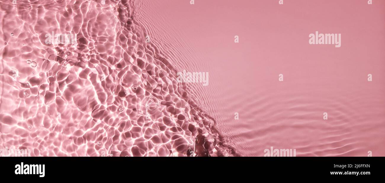 texture abstraite de la surface des vagues d'eau sur fond rose avec espace de copie. bannière Banque D'Images