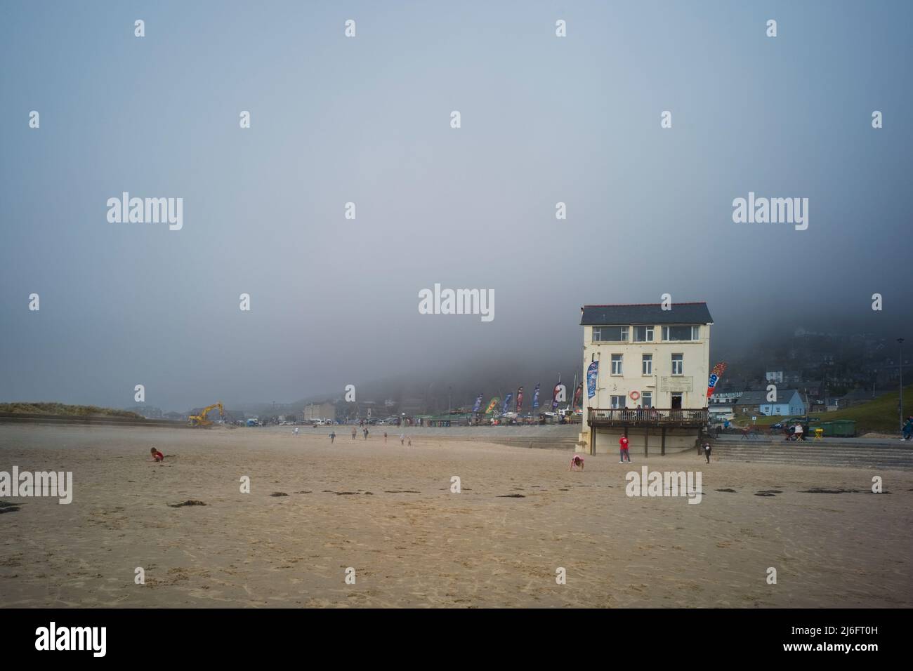 Plage de sable du port à marée basse avec une brume de mer lourde suspendue au-dessus de la ville de Barmouth, dans le nord du pays de Galles Banque D'Images