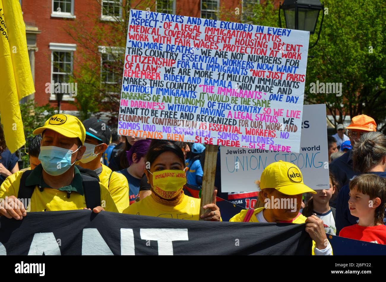 Les travailleurs tiennent des panneaux exigeant une protection renforcée des travailleurs lors de la parade du jour de mai au parc Washington Square à New York le 1 mai 2022. Banque D'Images