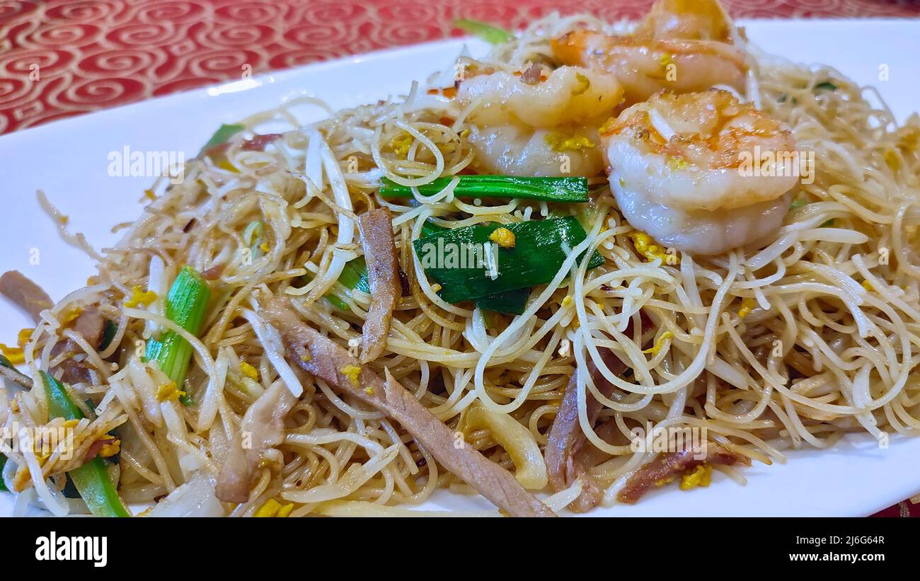 Faire sauter les nouilles de riz avec les crevettes, l'oignon vert et le soja. Cuisine chinoise. Banque D'Images