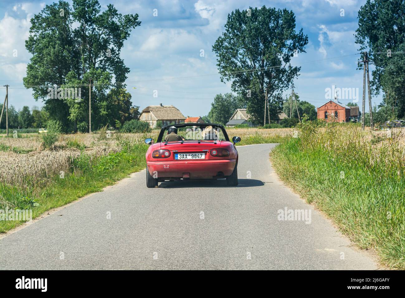 Wiaczemin Polski, Pologne - 12 août 2021. Voiture décapotable rétro rouge vintage sur une petite route entre les villages Banque D'Images
