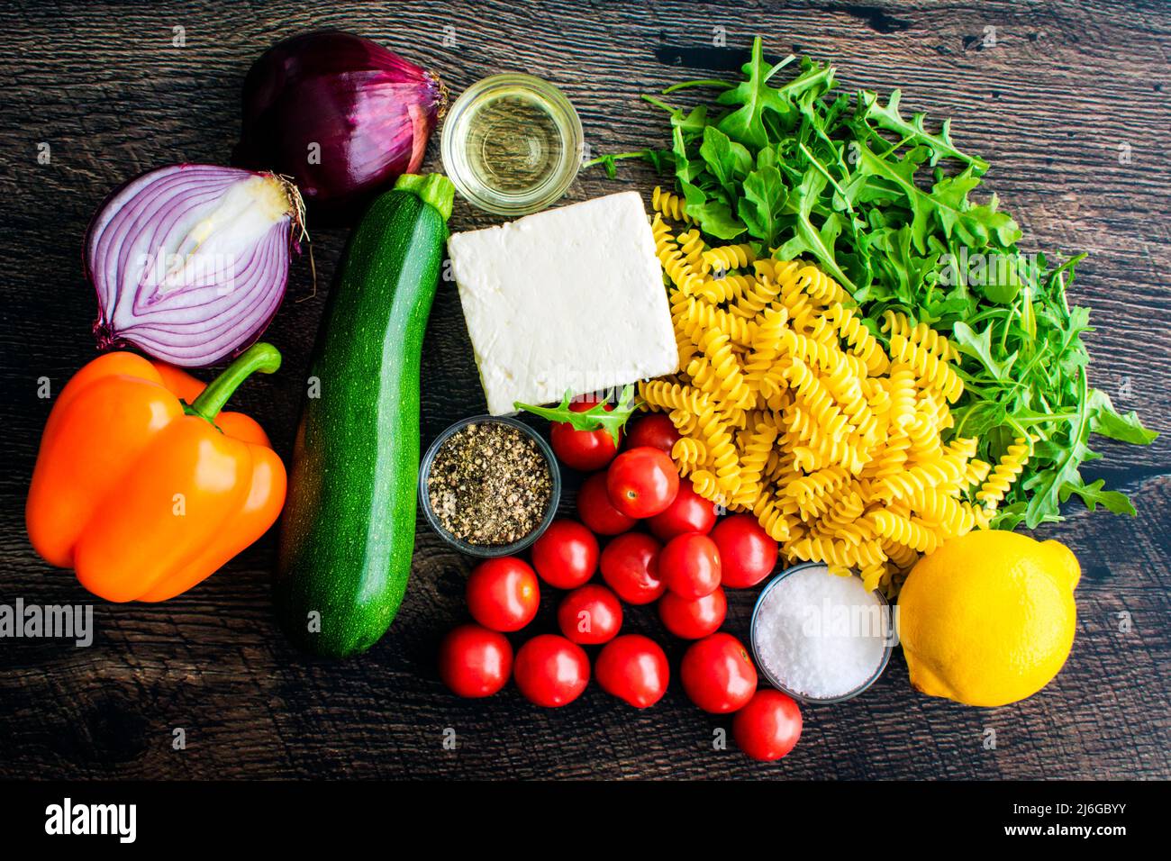 Vue en hauteur des pâtes de légumes rôties aux feta Ingrédients: Fromage feta, légumes, huile d'olive et autres ingrédients crus sur fond de bois Banque D'Images