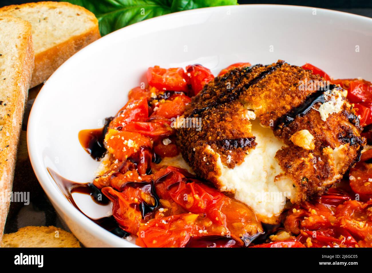 Gros plan vue de Burrata frit avec sauce aux tomates cerises apéritif : burrata frit servi avec une sauce aux tomates cerises, glaçure balsamique et ciabatta grillée Banque D'Images
