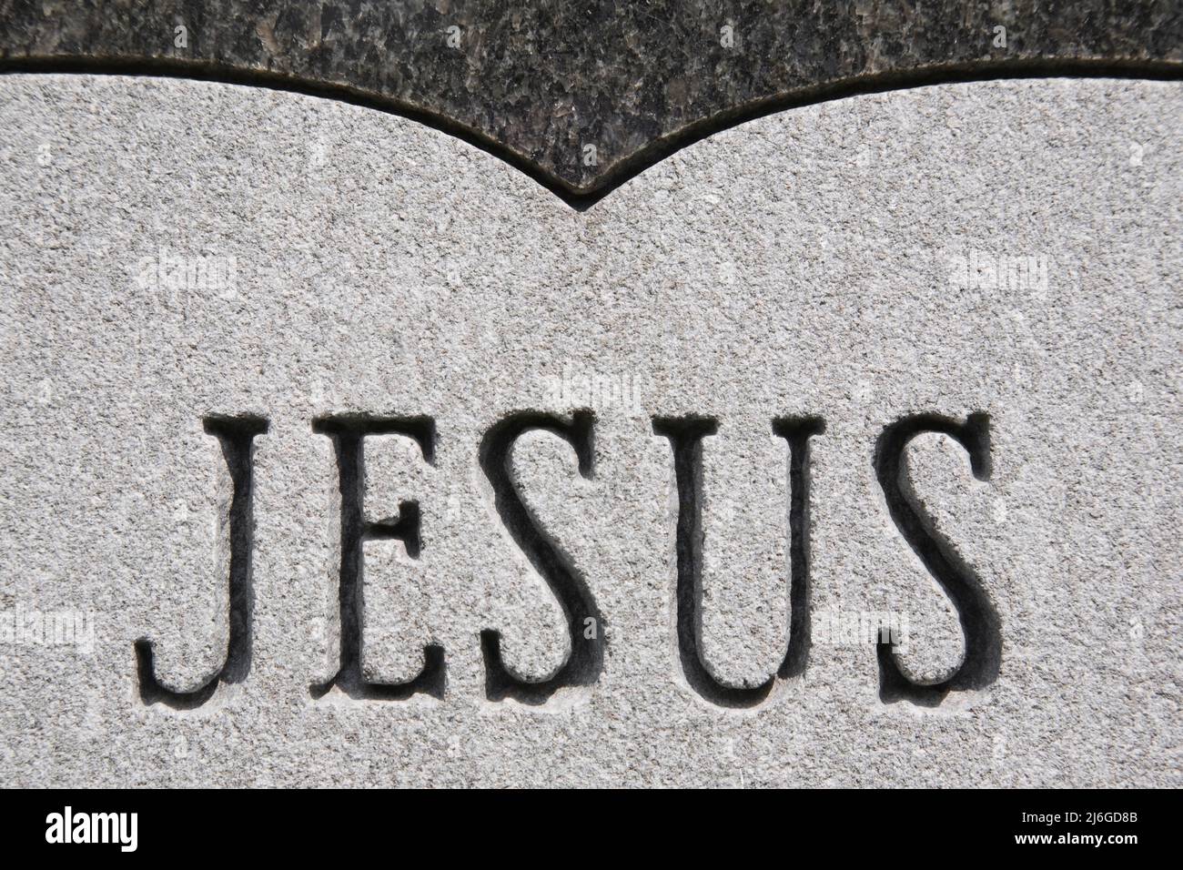 Inscription de Jésus sculpté sur un monument commémoratif dans un cimetière. Banque D'Images