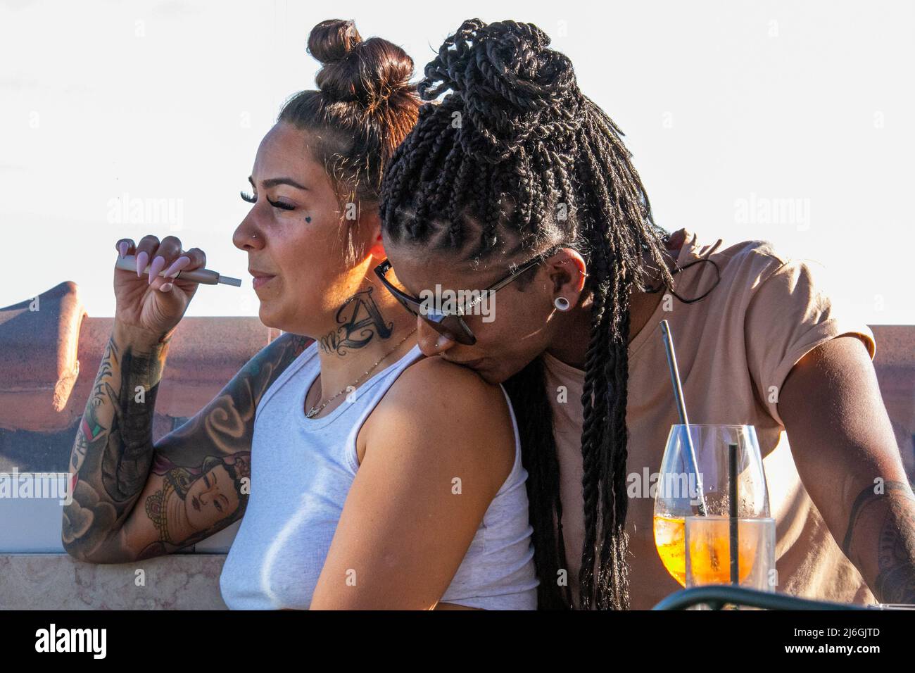 Cool mixte race lesbienne couple à un bar sur le toit à Lisbonne, Portugal Banque D'Images