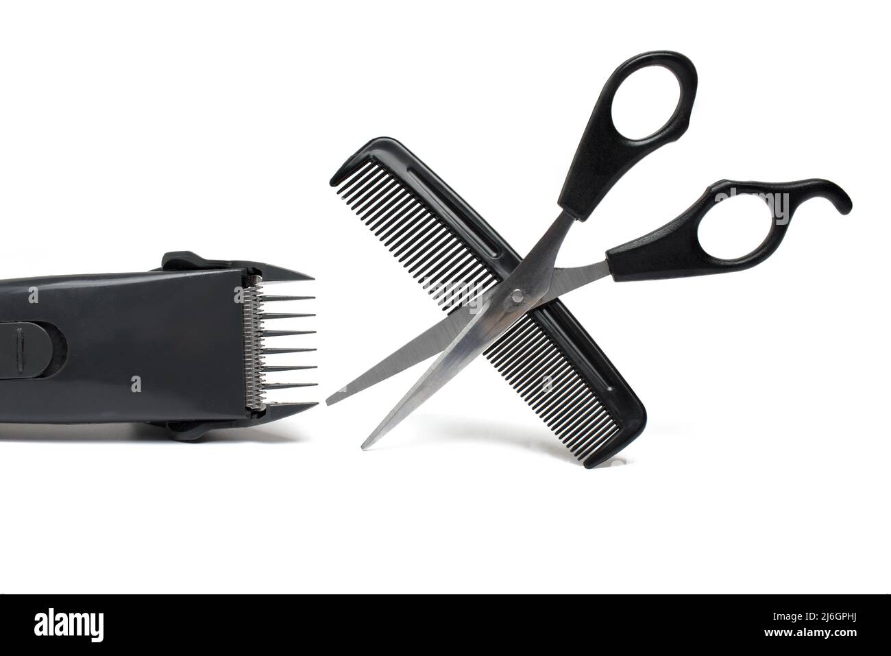 Gros plan de l'outil de coiffure d'une paire ouverte de ciseaux de coiffure  à côté d'une tondeuse à cheveux électrique et d'un peigne pour couper les  cheveux sur fond blanc Photo Stock -