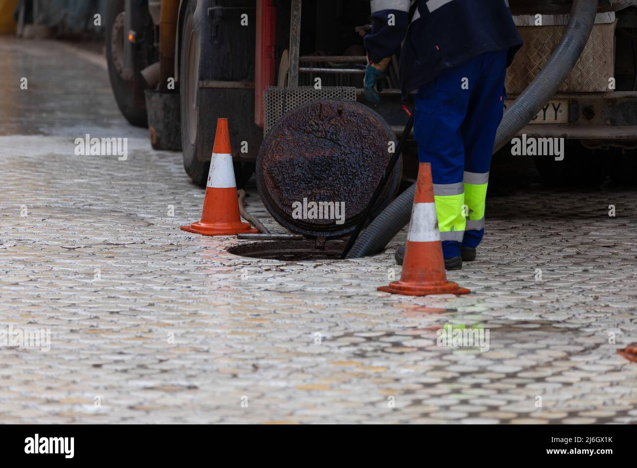 Nettoyage de la vidange, camion d'égout pompant de l'eau contaminée Banque D'Images