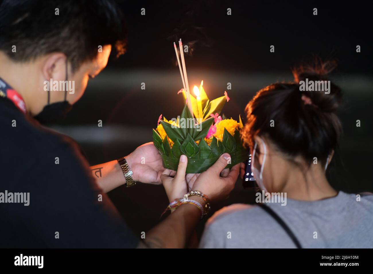 Krathong, un panier décoré de fleurs et de bougies, est prêt à être libéré à la mer lors d'une nuit de célébration de Loy Krathong en Thaïlande Banque D'Images