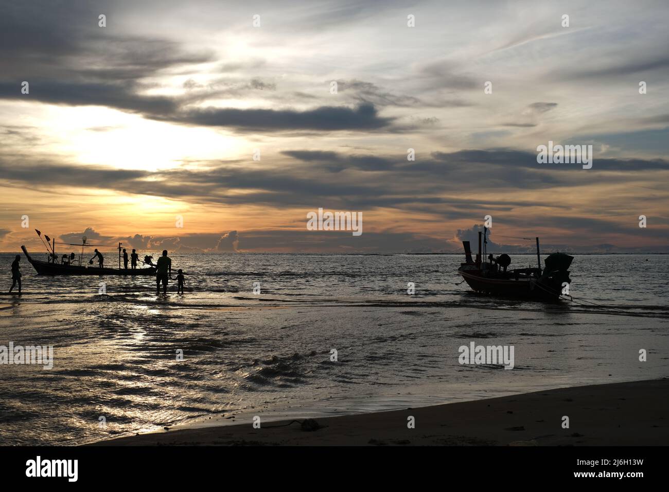 Les membres d'une famille de pêcheurs préparent des bateaux pour un voyage de nuit à la mer d'Andaman Banque D'Images