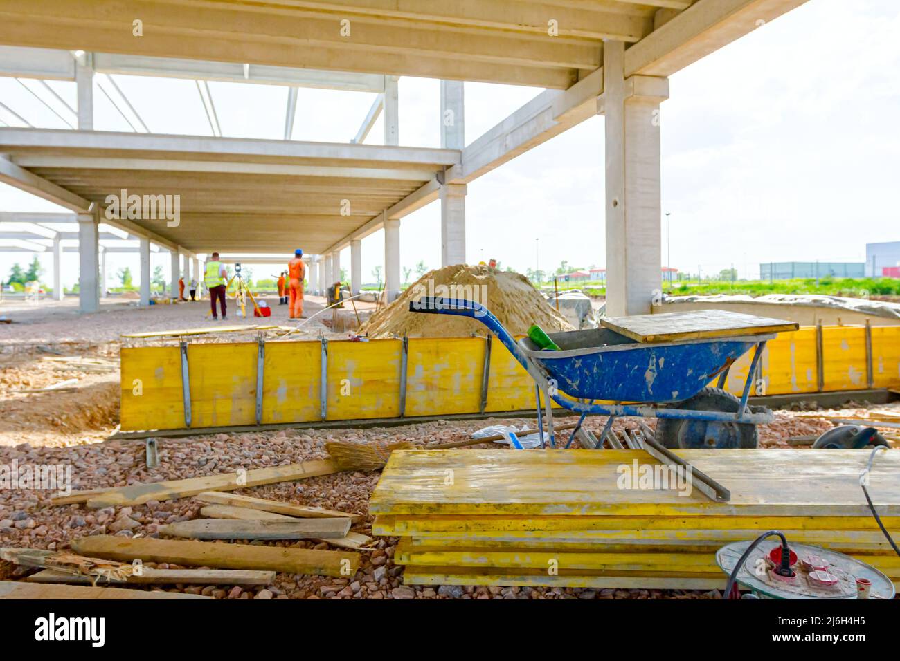 Vue sur les brouettes d'occasion avec des planches en bois peintes et empilées sont empilées sur le chantier. Les fauteurs, les travailleurs sont des moules longs d'assemblage pour le béton. Banque D'Images