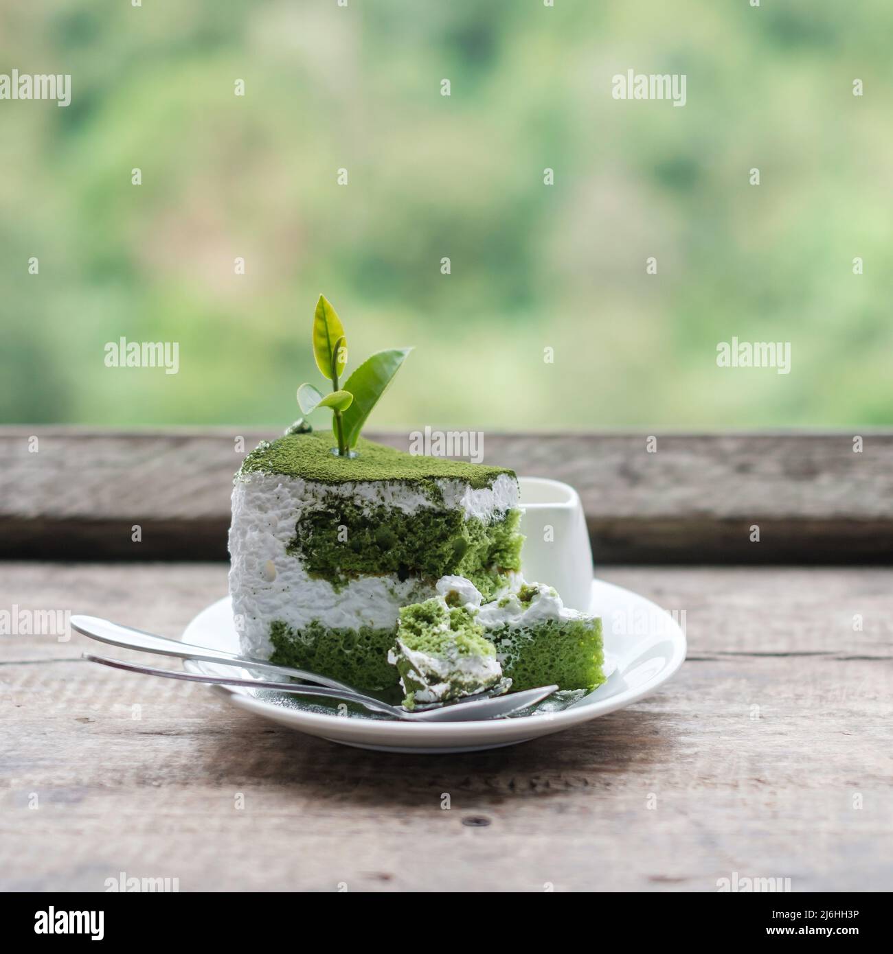 Gâteau de thé vert avec feuille de thé de jeune bourgeon sur une table en bois sur fond de jardin de thé Banque D'Images